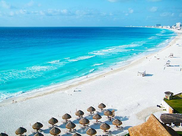 Beautiful ocean at Cancun Beach Mexico.  Beach Umbrellas and white sand.