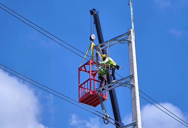 istock Men in work clothes and hard hats are installing high-voltage wires on a power pole 2207615664