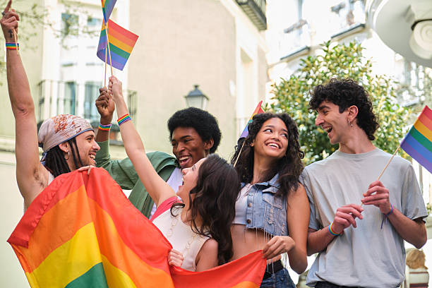 istock Young activists waving rainbow flags at a LGBT pride parade 2207616957