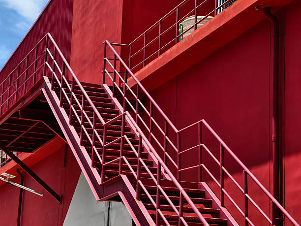 istock A set of stairs ascending a large red wall 2207617176