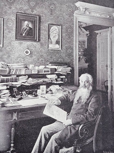 istock Man with white hair and long beard sitting at his desk 2207617714