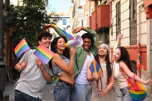 istock Young activists celebrating gay pride holding rainbow flags and megaphone 2207619403