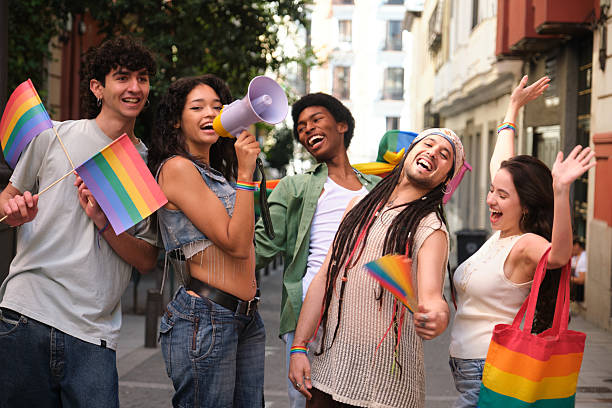 istock Young activists marching for LGBT rights with rainbow flags and megaphone 2207619561