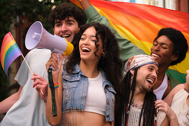istock Young activists shouting with megaphone at lgbt pride parade 2207619738