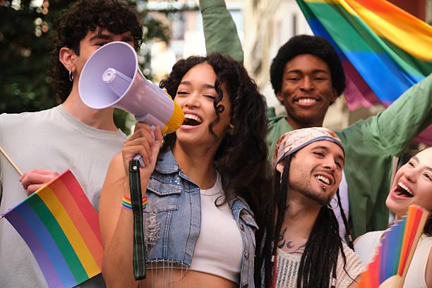 istock Young woman speaking with megaphone at LGBT pride parade 2207619811