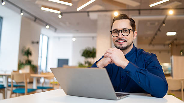 istock Smiling man working on a laptop in a contemporary coworking space, engaging with technology. 2207622997