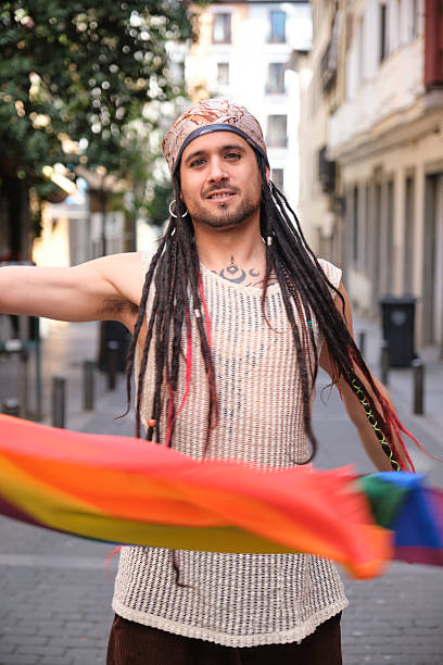 istock Young man with dreadlocks waving rainbow flag in the city 2207624118