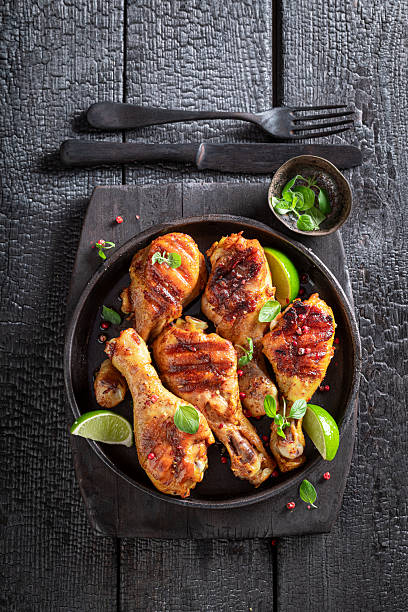 istock Hot grilled chicken leg served with lime and herbs. 2207624166