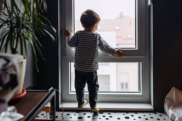 istock Curious toddler looking out the window at home 2207633191