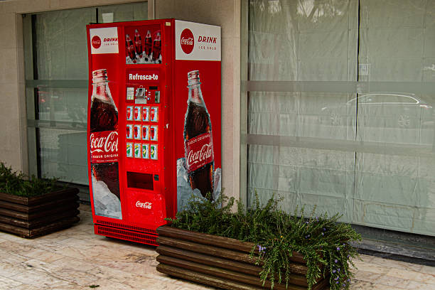 Fatima, Portugal - March 24, 2025: Red beverage Coca Cola vending machine located near a building, in Fatima, Portugal.