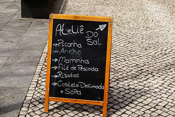 Fatima, Portugal - March 24, 2025: A blackboard menu Atelie do Sal showcasing food items on cobblestone pavement in Fatima.