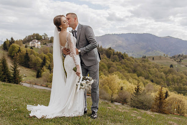 istock A bride and groom are kissing on a grassy hillside 2207636432
