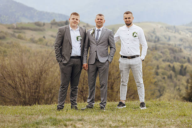 istock Three men in suits stand on a grassy hillside, posing for a photo 2207636533