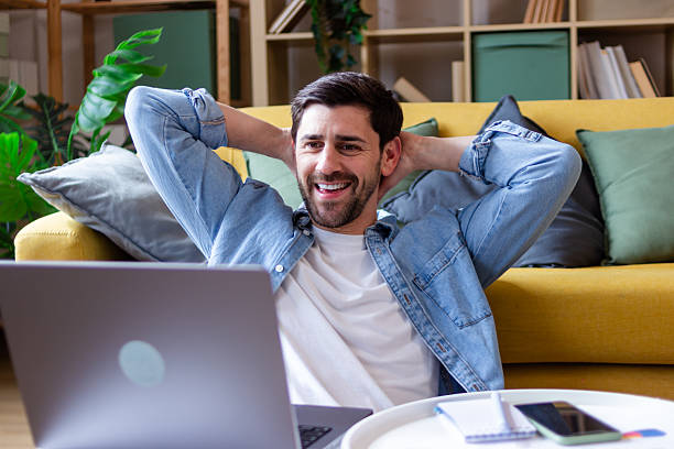 istock Young man relaxing at home after finishing work on his laptop 2207637486