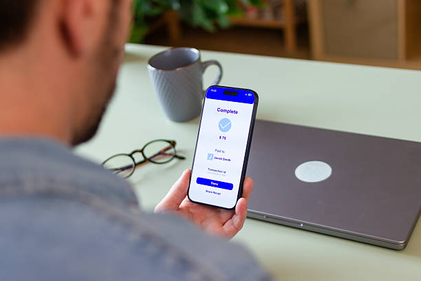 istock Man completing mobile payment on smartphone at home 2207638760