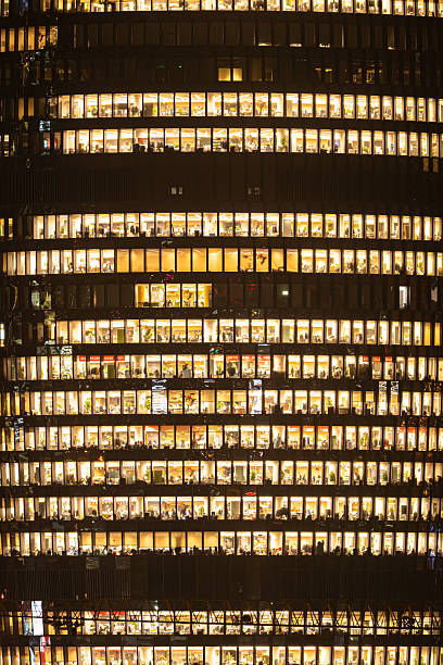 istock People are working overtime in brightly lit office buildings late at night 2207642373