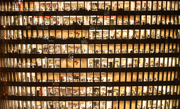 istock People are working overtime in brightly lit office buildings late at night 2207642887