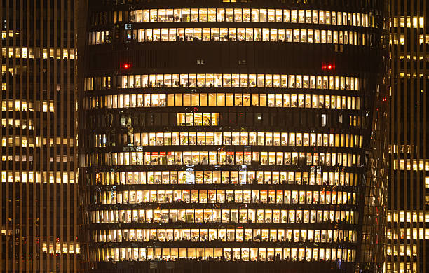 istock People are working overtime in brightly lit office buildings late at night 2207643062