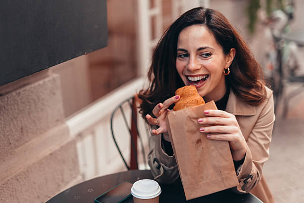 istock Happy customer enjoying a delicious pastry outside a bakery 2207646060