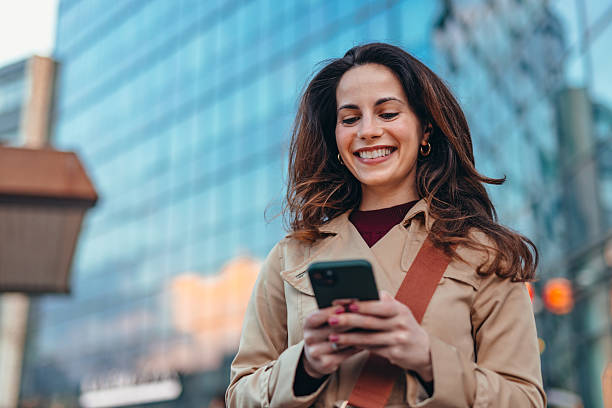 istock Smiling businesswoman using smartphone in urban city setting 2207646417