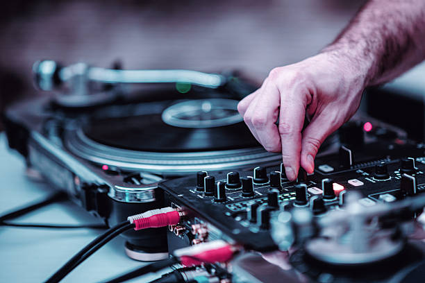 Close-up of a DJ controller illuminated by vibrant LED lights, showcasing buttons and controls in a dynamic setting. Perfect for music and party-themed visuals.