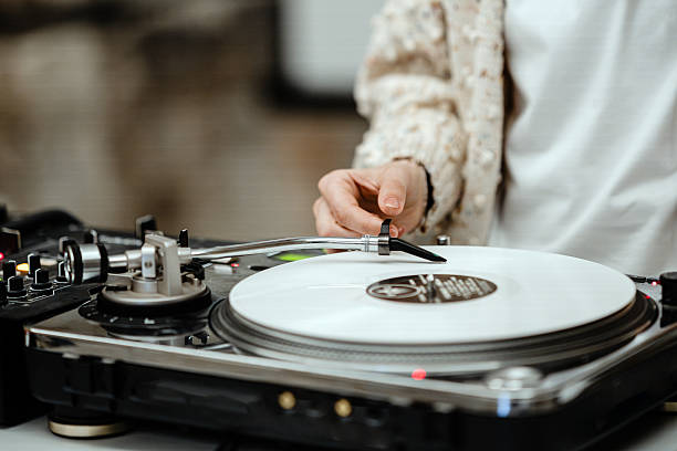 istock Female DJ in studio placing the needle on a vinyl record. 2207646691