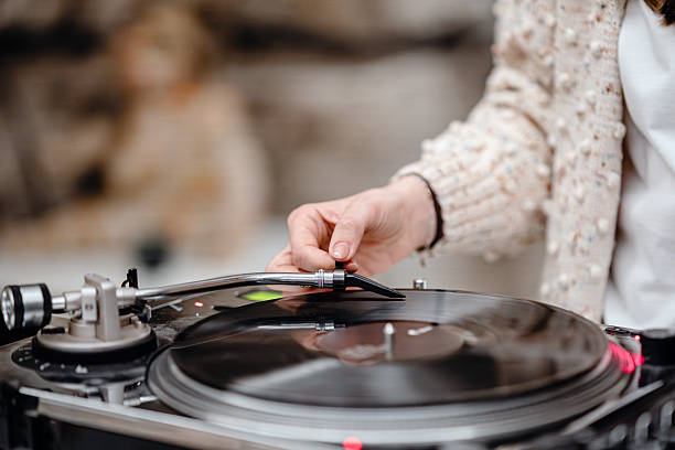 istock Female DJ in studio placing the needle on a vinyl record. 2207646725