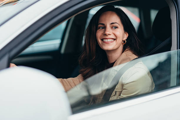 istock Young businesswoman smiling while driving her car 2207646806