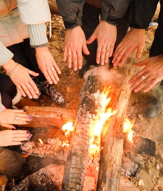 Men's hands, women's, children's hands against a bonfire