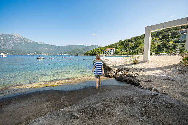 istock The boy dressed runs straight into the sea to cool off 2207647490