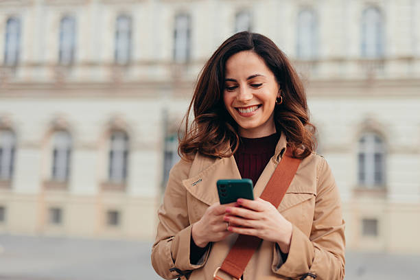 istock Smiling businesswoman using smartphone in urban city setting 2207647531