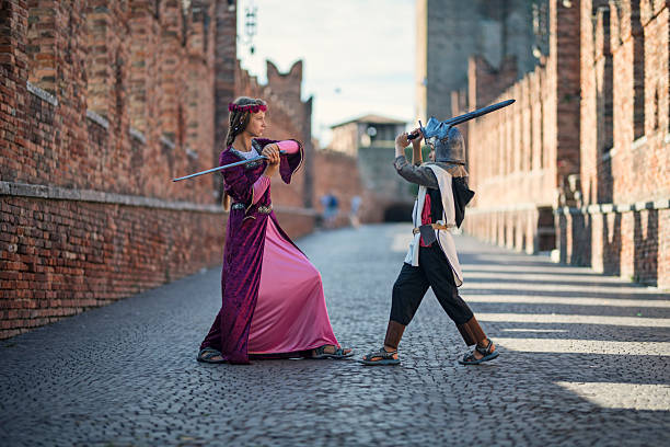 istock Little princess practicing swordplay with a little knight on the medieval bridge 2207648860