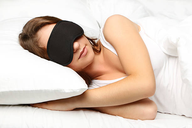 istock Young woman sleeping with eyemask in white bed 2207653914
