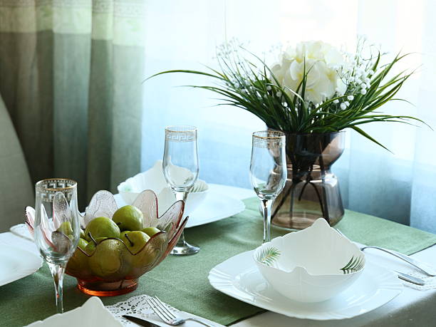 An elegantly arranged dining table with exquisite tableware, fresh fruits, and floral decor for any gathering