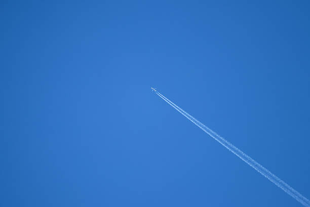istock An airplane flying at high altitude leaving its trail in a blue sky. 2207660709