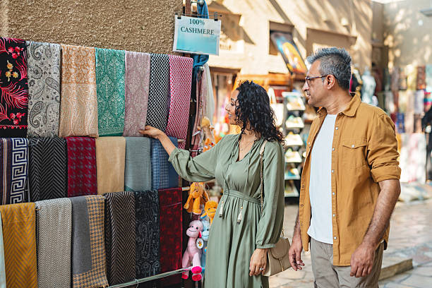istock Middle Eastern Couple Exploring Al Fahidi Souk with Colorful Fabrics in Bright Daylight 2207666682