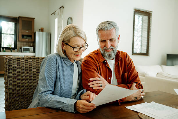 istock Mature couple going over paperwork at home together 2207667616