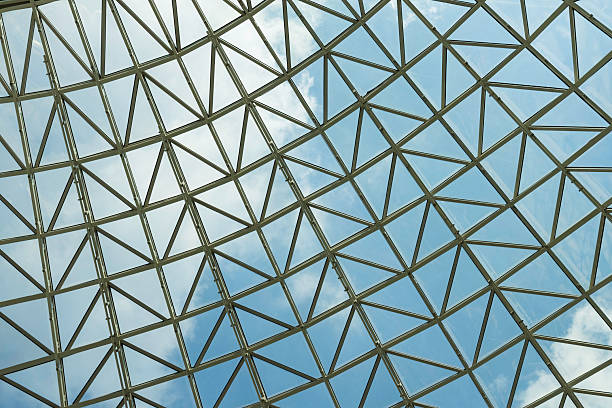 istock Modern glass roof structure featuring intricate metal framework and clear blue sky during midday sunlight in an urban setting 2207673488
