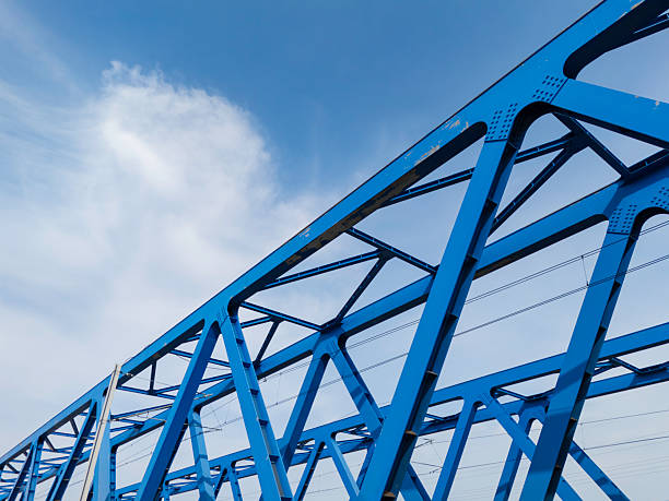 istock Blue metal bridge construction over water with rail tracks visible, showcasing engineering and design 2207674143