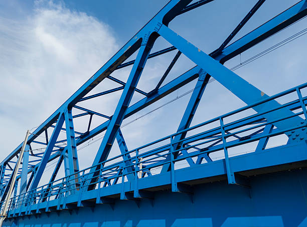 istock Blue metal bridge construction over water with rail tracks visible, showcasing engineering and design 2207674149