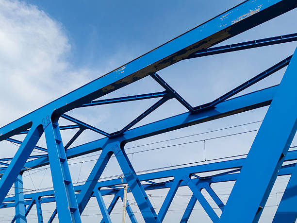istock Blue metal bridge construction over water with rail tracks visible, showcasing engineering and design 2207674171