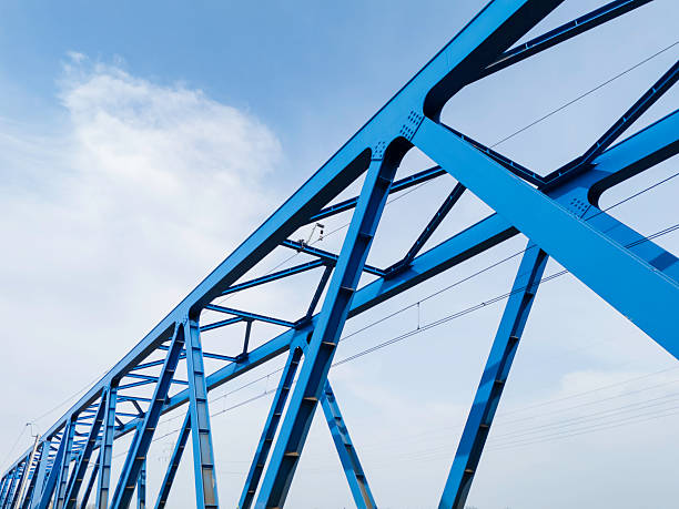 istock Blue metal bridge construction over water with rail tracks visible, showcasing engineering and design 2207674315