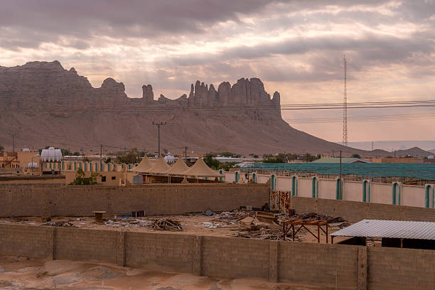 istock A Saudi desert settlement with scattered debris, rocky cliffs in the backdrop, and a mix of small buildings and tents creating a striking contrast 2207674786