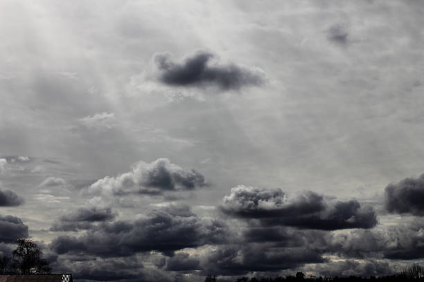 The sun shining through the dark clouds