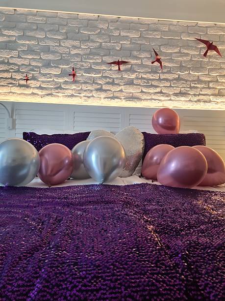 Bedroom decorated with balloons and heart shaped pillow