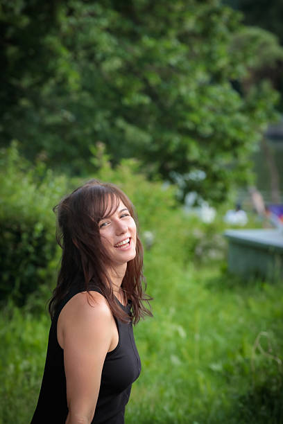 istock Girl with a smile on a park bench 2207677919