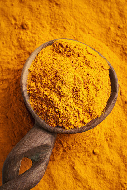 istock Turmeric root powder on a spoon, top view 2207682747