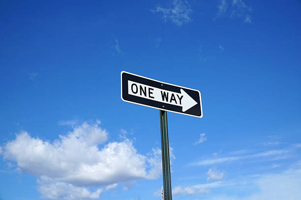 istock one way sign in front of blue sky and white cloud 2207683584