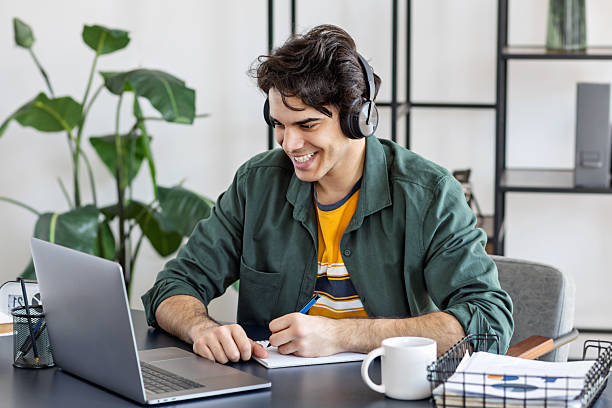 istock Young man learning online with headphones home 2207683785