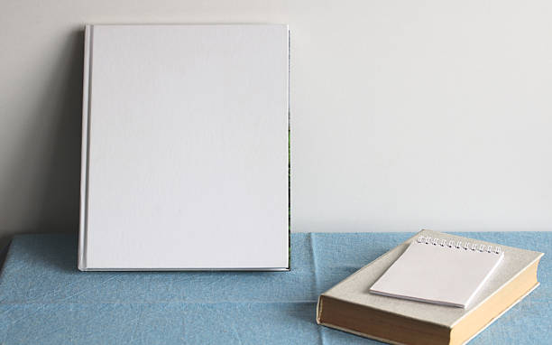 istock White hardcover book, notepad and textbook resting on blue tablecloth 2207684023